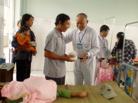 Ông Sáu (thứ 3 từ phải sang) trao cơm cho thân nhân người bệnh.