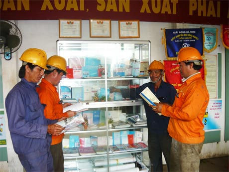 Công nhân đọc sách, báo, tìm hiểu thông tin tại góc BHLĐ của Công ty TNHH Một thành viên Đổng Kim Long.