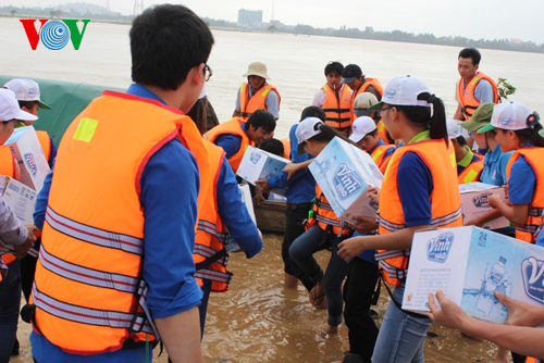 Lực lượng thanh niên cấp phát nước uống cho bà con vùng lũ. 