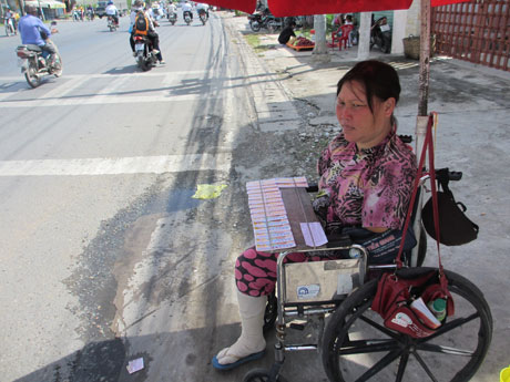 Chị Võ Thị Còn, chỉ còn 1 chân, hàng ngày vẫn đội nắng, dầm mưa bán vé số nuôi con.