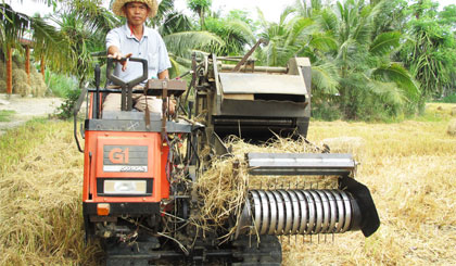 Anh Nguyễn Ngọc Thuận đang vận hành thử “Máy cuốn rơm tự hành” do anh sáng chế.
