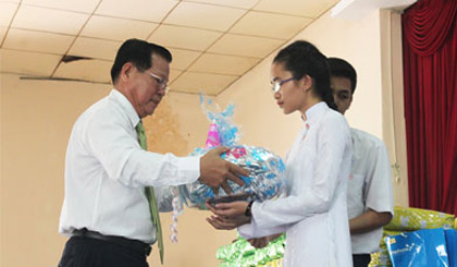 Ông Nguyễn Văn Khang, Chủ tịch UBND tỉnh khen thưởng em Võ Thị Mỹ Diện, học sinh xuất sắc toàn trường.
