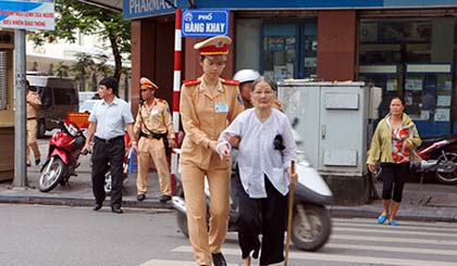 Cảnh sát giao thông giúp người già qua đường. Ảnh: Báo Công an nhân dân