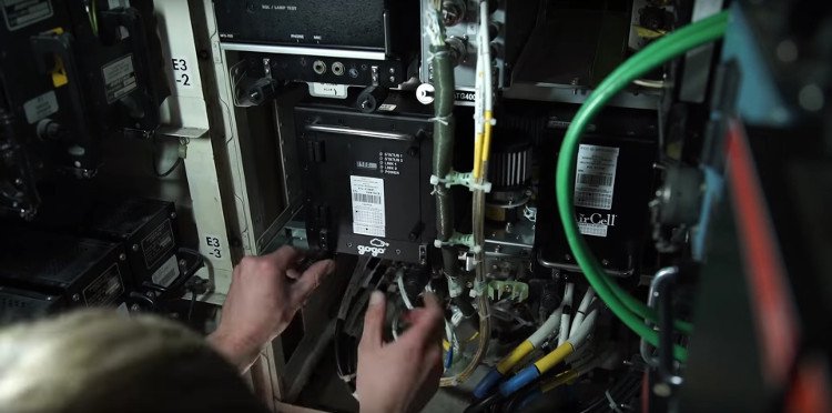 Một nhân viên kỹ thuật đang lắp đặt khối kết nối vệ tinh lên máy bay Boeing 747.