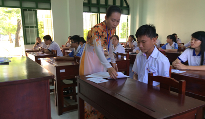 Giám thị hướng dẫn TS ghi thông tin vào giấy làm bài.