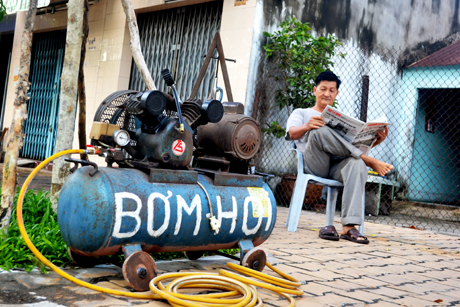 Chú sửa xe đang chờ đợi vị khách đầu tiên.