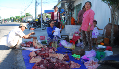 Người dân vẫn bày bán thịt heo tràn lan dưới đất tại ven Quốc lộ 50, xã Mỹ Phong, TP. Mỹ Tho.