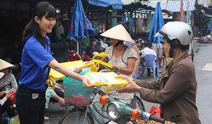 Đoàn viên tặng túi thân thiện với môi trường cho người dân ở chợ Mỹ Tho.