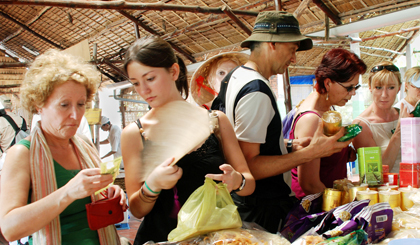 Du khách mua sắm ở làng nghề. Ảnh: VÕ NGUYÊN PHÚ