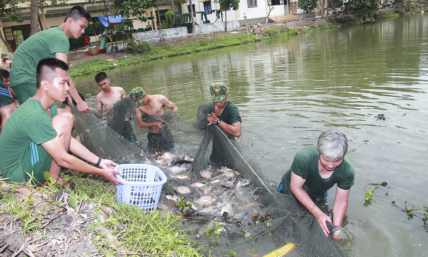 Cán bộ cùng chiến sĩ bắt cá để cải thiện bữa ăn.