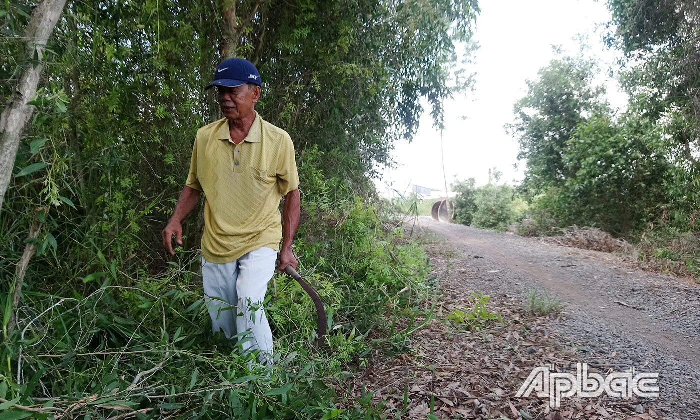 Ông Nguyễn Văn Chiêu chặt mé cây xanh nhằm tạo thuận lợi cho thực hiện công trình giao thông.