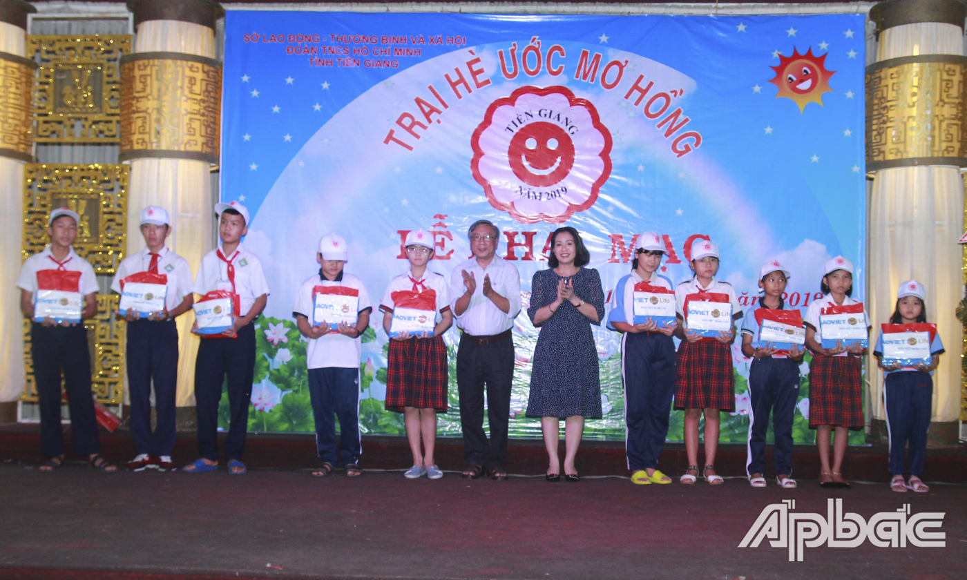 Ban tổ chức và nhà tài trợ trao quà cho các em có hoàn khó khăn tham gia Trại hè.