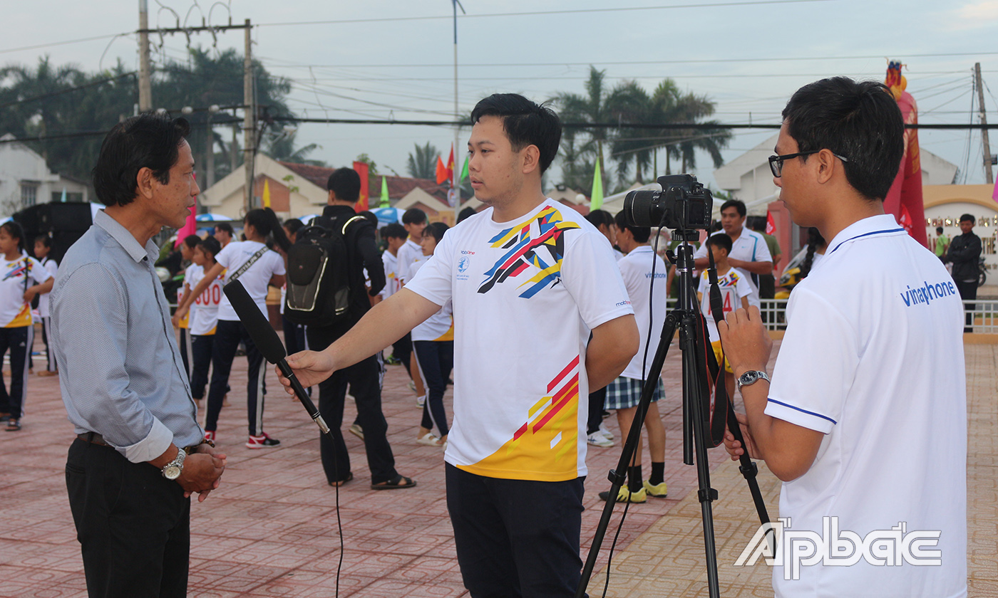 PV Văn Thảo (bìa phải) trong một lần tác nghiệp ở Giải Việt dã Báo Ấp Bắc 2018. Ảnh: BẠCH CÚC.