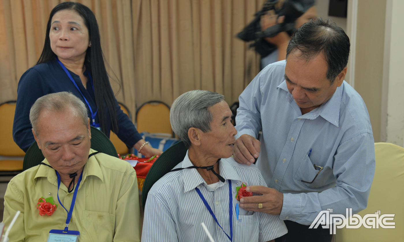 Cài hoa và tặng quà cho các cựu chiến binh tham quan Nhà tù Côn Đảo