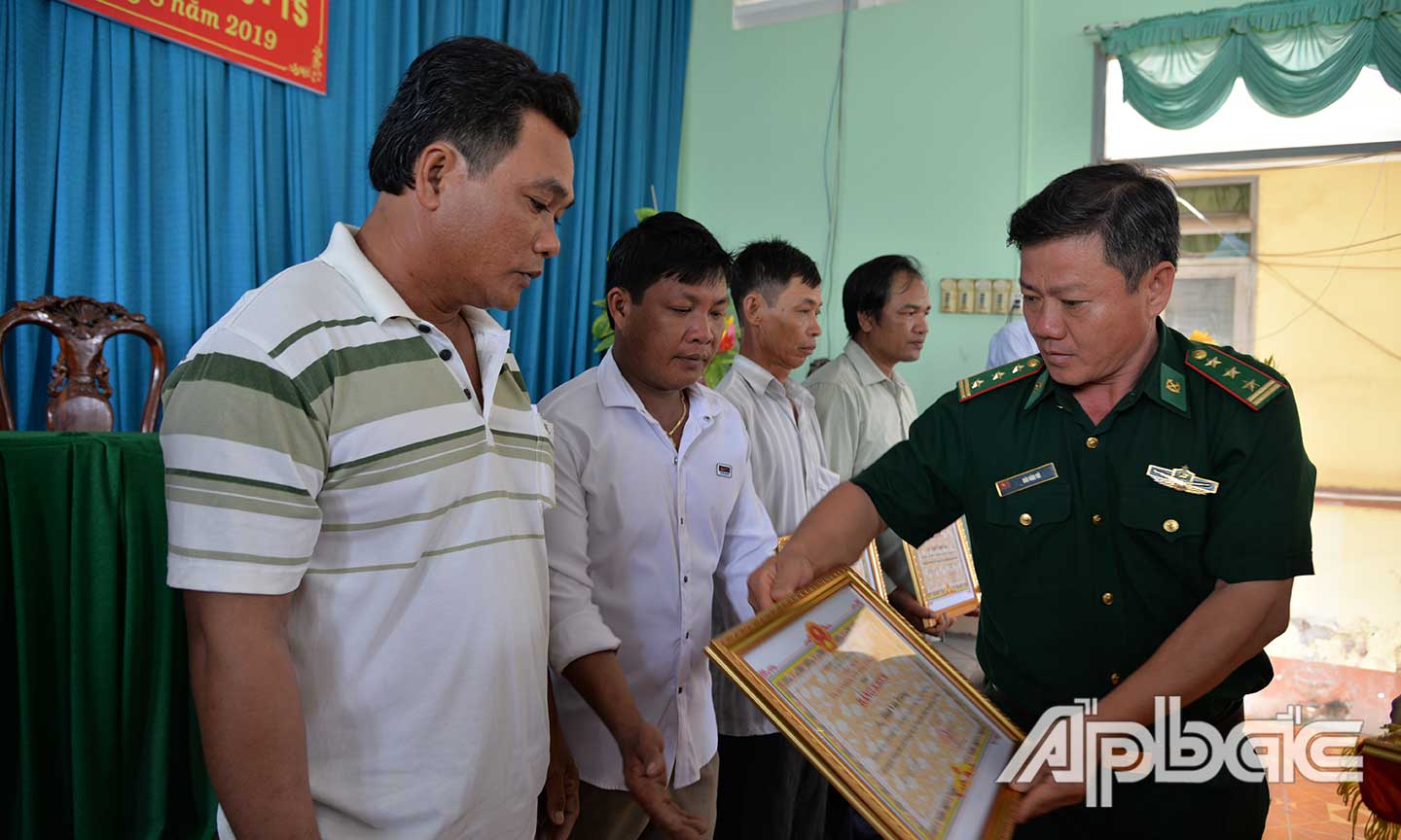 Đại diện Bộ Chỉ huy Bộ đội Biên phòng tỉnh trao Bằng khen  của UBND tỉnh cho thuyền trưởng và các ngư dân.