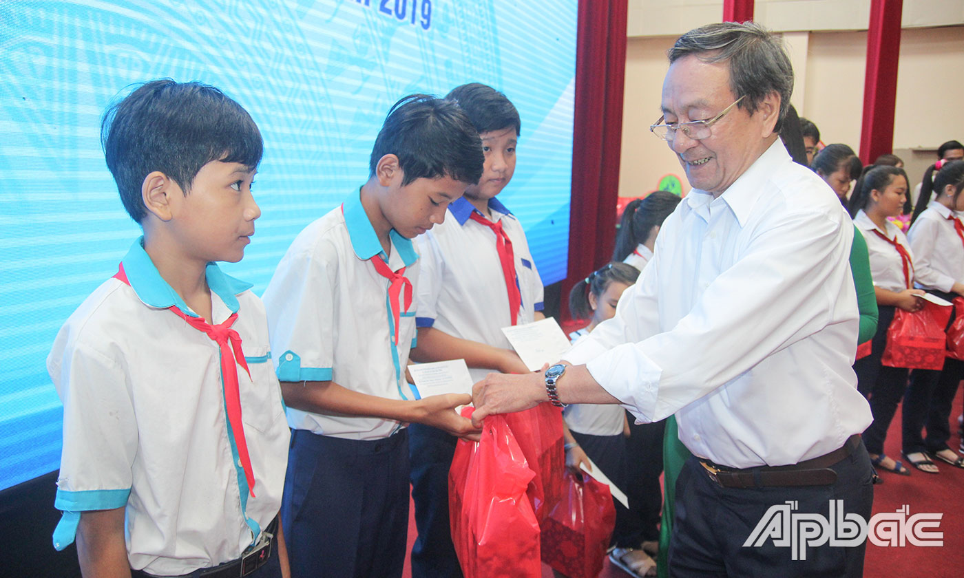 Chủ tịch Danh dự Hội Bảo trợ bệnh nhân nghèo, người khuyết tật và trẻ mồ côi tỉnh Phan Văn Hà trao học bổng cho các em học sinh.
