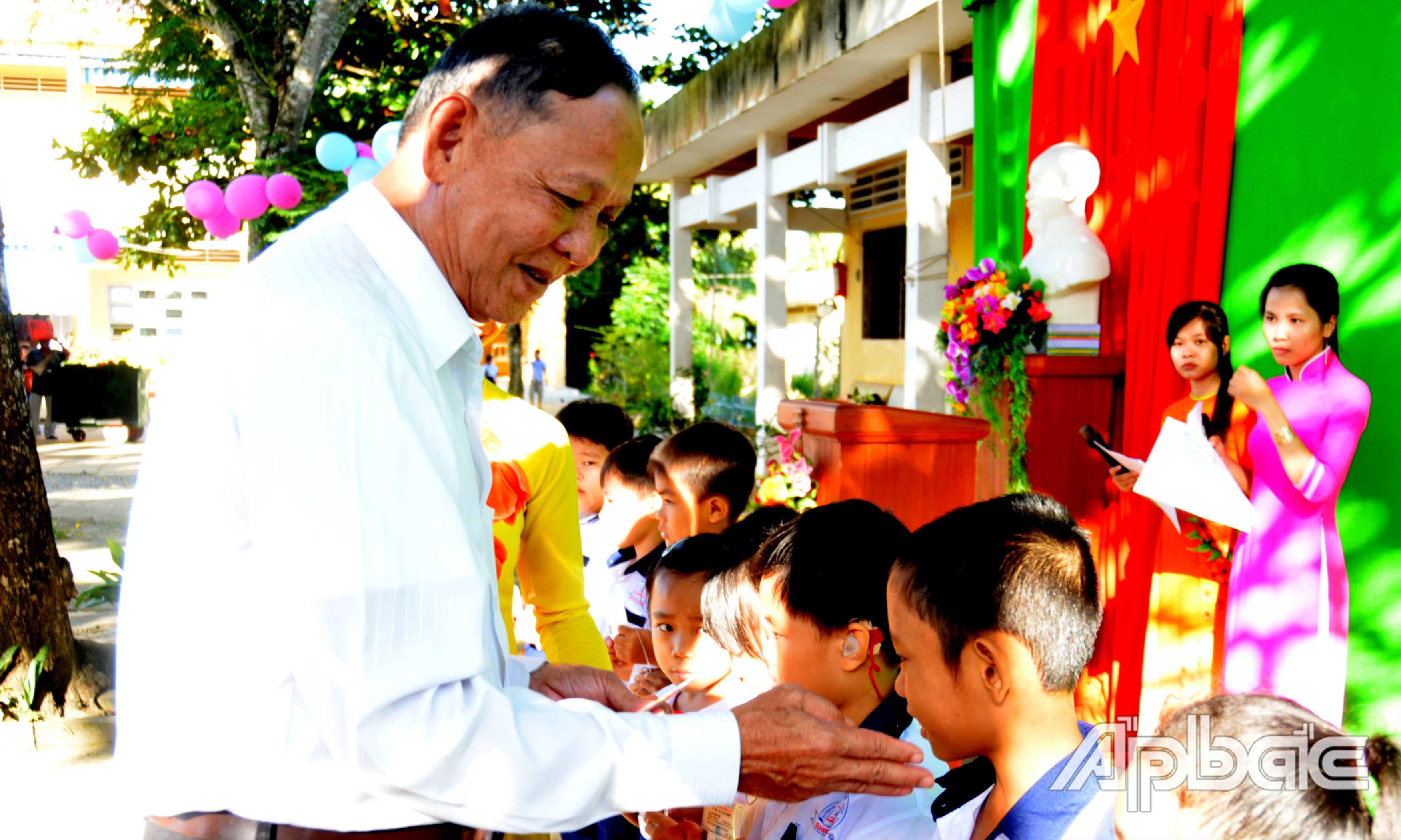 Trung tướng Nguyễn Việt Thành trao thẻ bảo hiểm y tế cho học sinh có hoàn cảnh khó khăn của Trường Tiểu học Thanh Bình. Ảnh: HỒNG PHƯỢNG