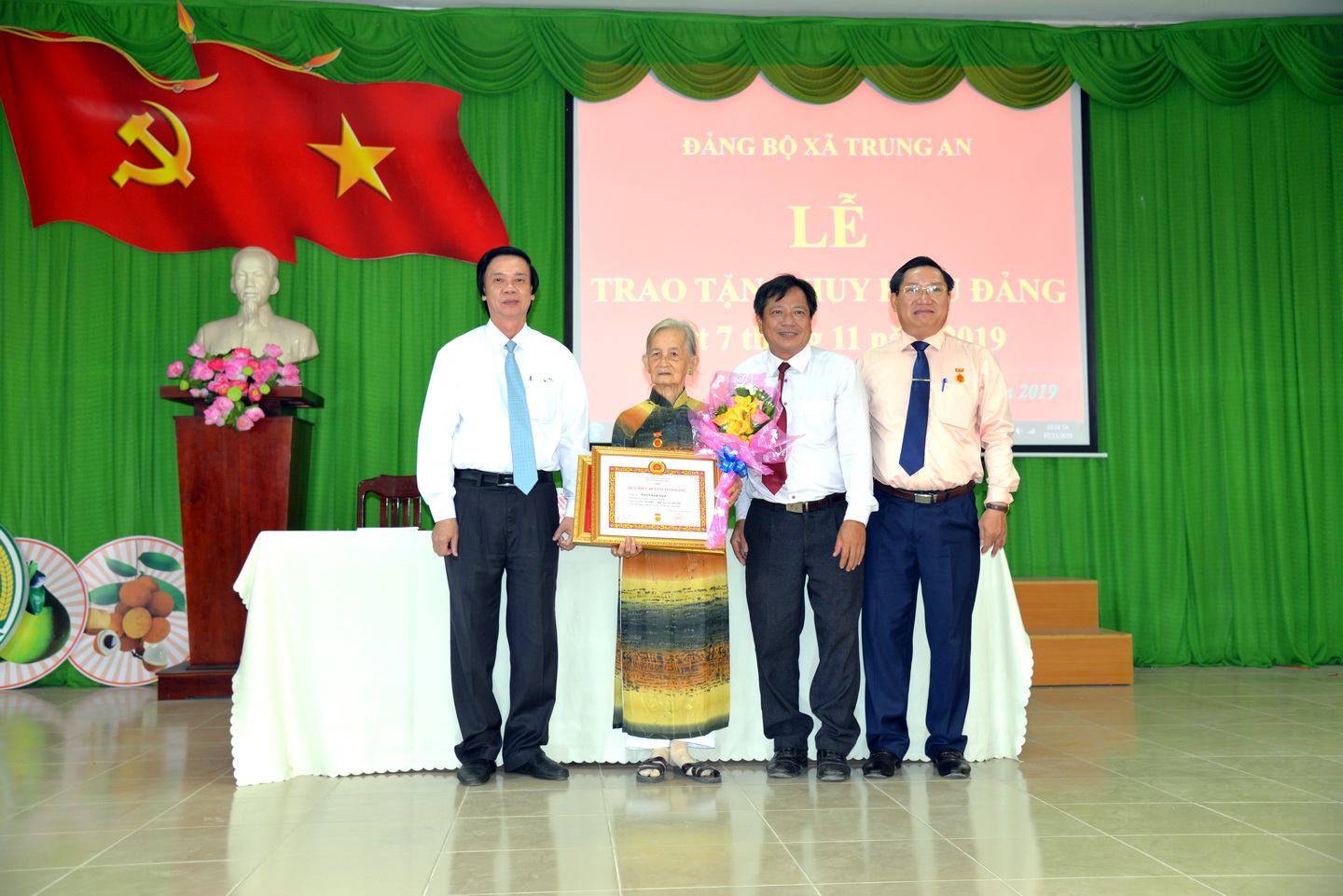 Bí thư Tỉnh ủy Nguyễn Văn Danh trao Huy hiệu 60 năm tuổi đảng và Bí thư Thành ủy Mỹ Tho, Bí thư Đảng ủy xã Trung An trao hoa, quà, khánh vàng cho đảng viên Phan Kim Anh