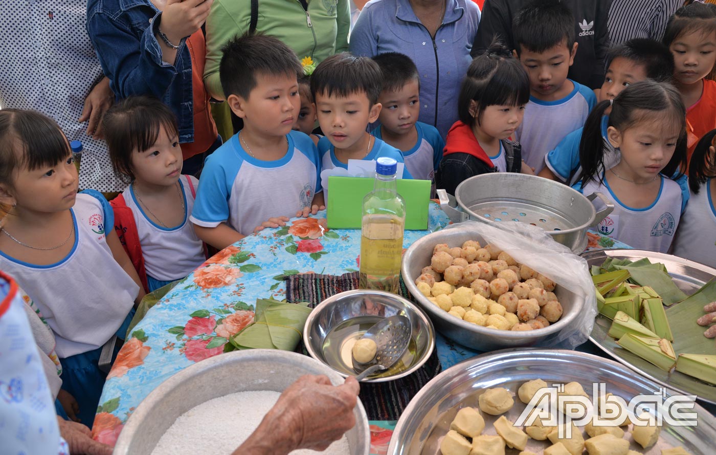 Nhiều phụ huynh chở con em đến tham quan Hội thi bánh dân gian Nam bộ năm 2019