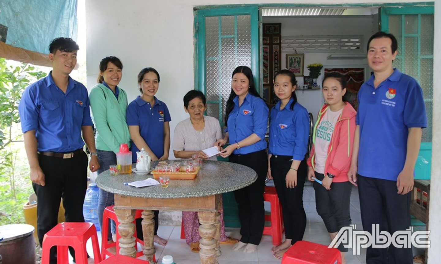 Chị Hương (thứ 4 từ phải qua) và ĐV-TN tặng quà cho gia đình  chính sách tại xã Thới Sơn (TP. Mỹ Tho).