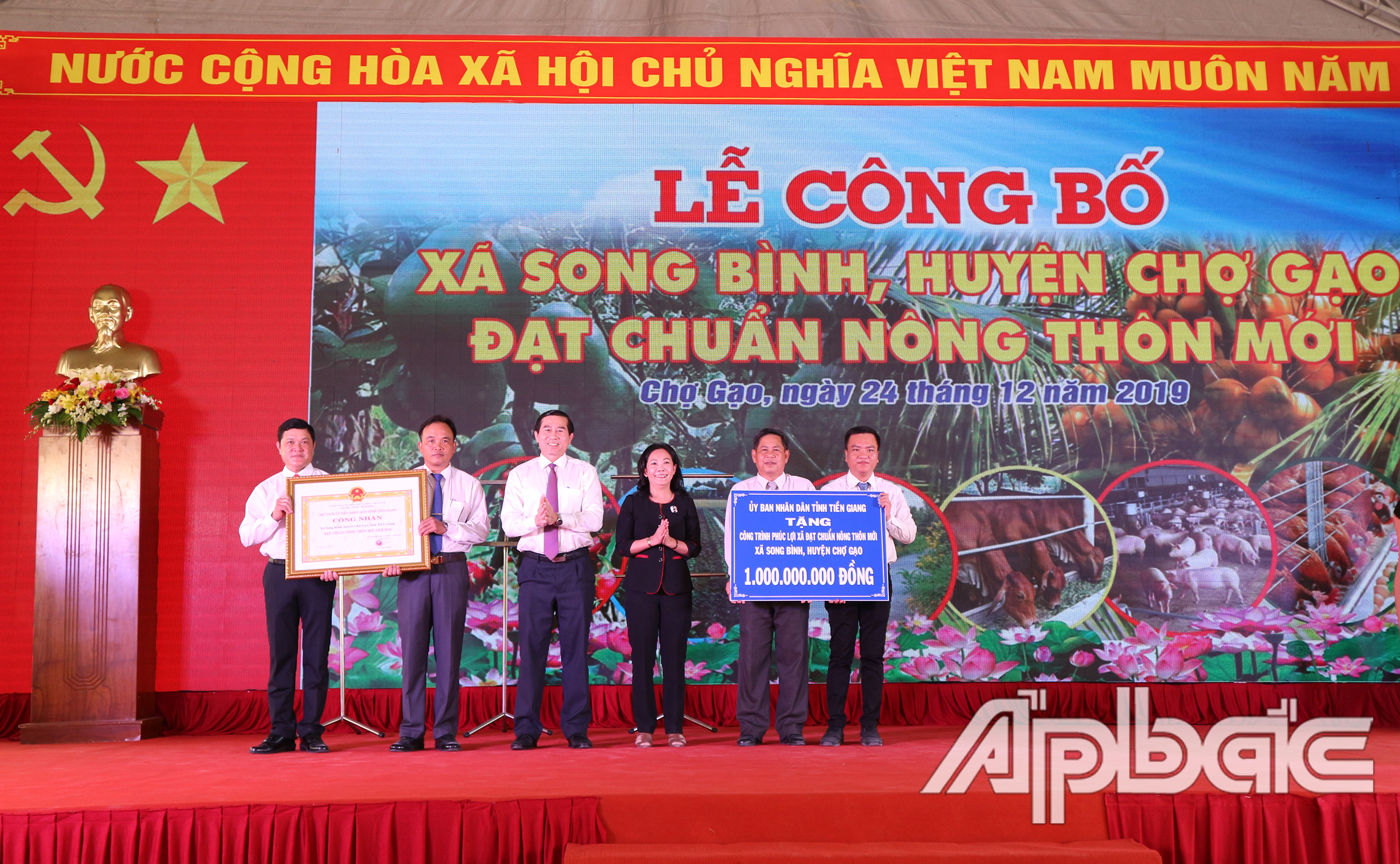  Đồng chí Lê Văn Hưởng và đồng chí Nguyễn Thị Sáng trao Bằng công nhận xã đạt chuẩn NTM và Bảng tương trưng công trình phúc lợi 1 tỷ đồng cho xã Song Bình