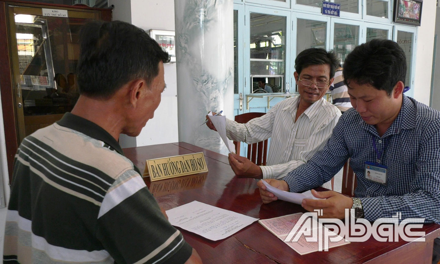 Cán bộ Bộ phận tiếp nhận và trả kết quả UBND xã Hiệp Đức hướng dẫn người dân giải quyết hồ sơ tại trụ sở UBND xã.