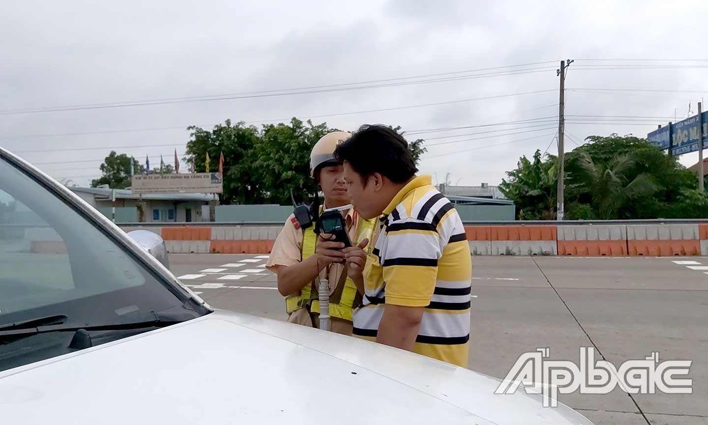 Cảnh sát giao thông kiểm tra nồng độ cồn đối với người điều khiển phương tiện tham gia giao thông.       Ảnh: ĐỨC THỊNH