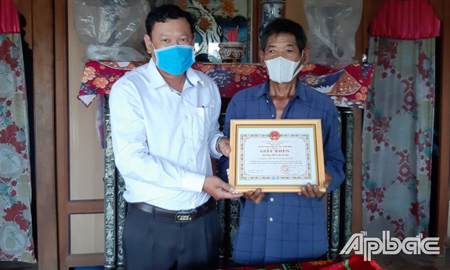 Đại diện lãnh đạo xã trao giấy khen cho ông Lê Văn Tưởng.