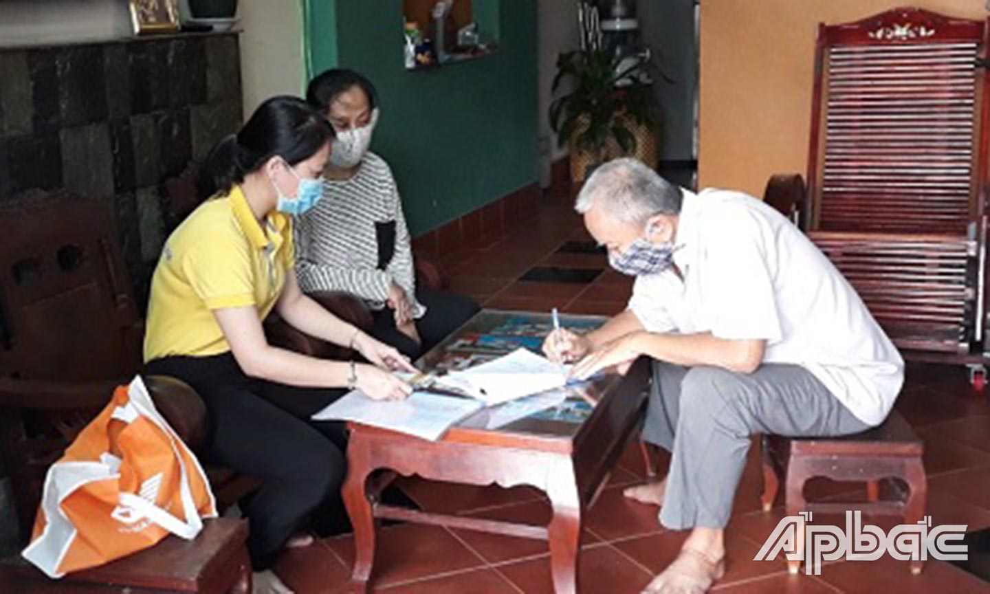 Nhân viên Bưu điện chi trả lương hưu tận nhà cán bộ hưu trí ở phường 7, TP. Mỹ Tho.