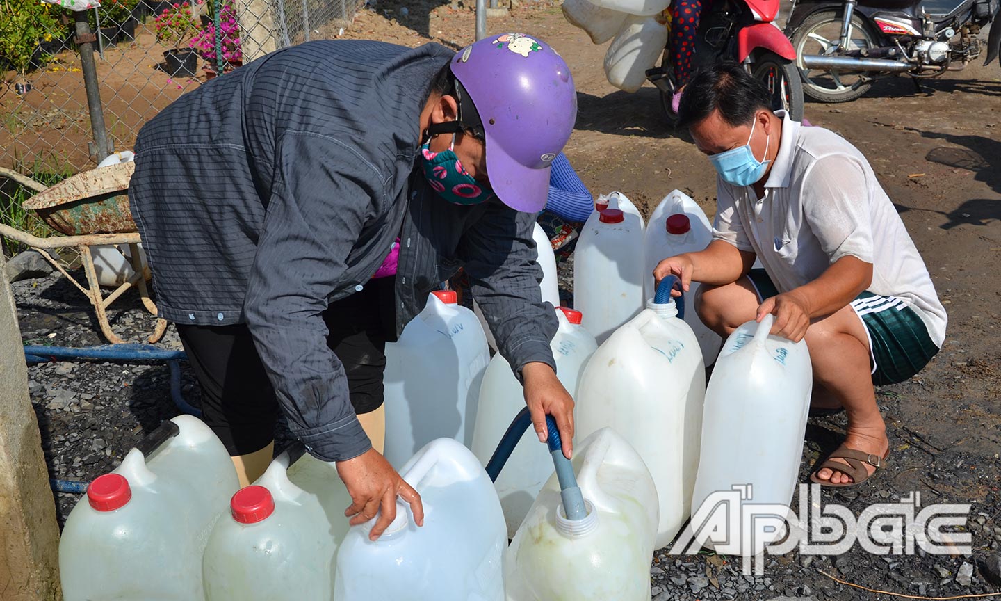 Người dân xã Tân Đông (huyện Gò Công Đông) đến lấy nước tại vòi nước công cộng trên địa bàn.
