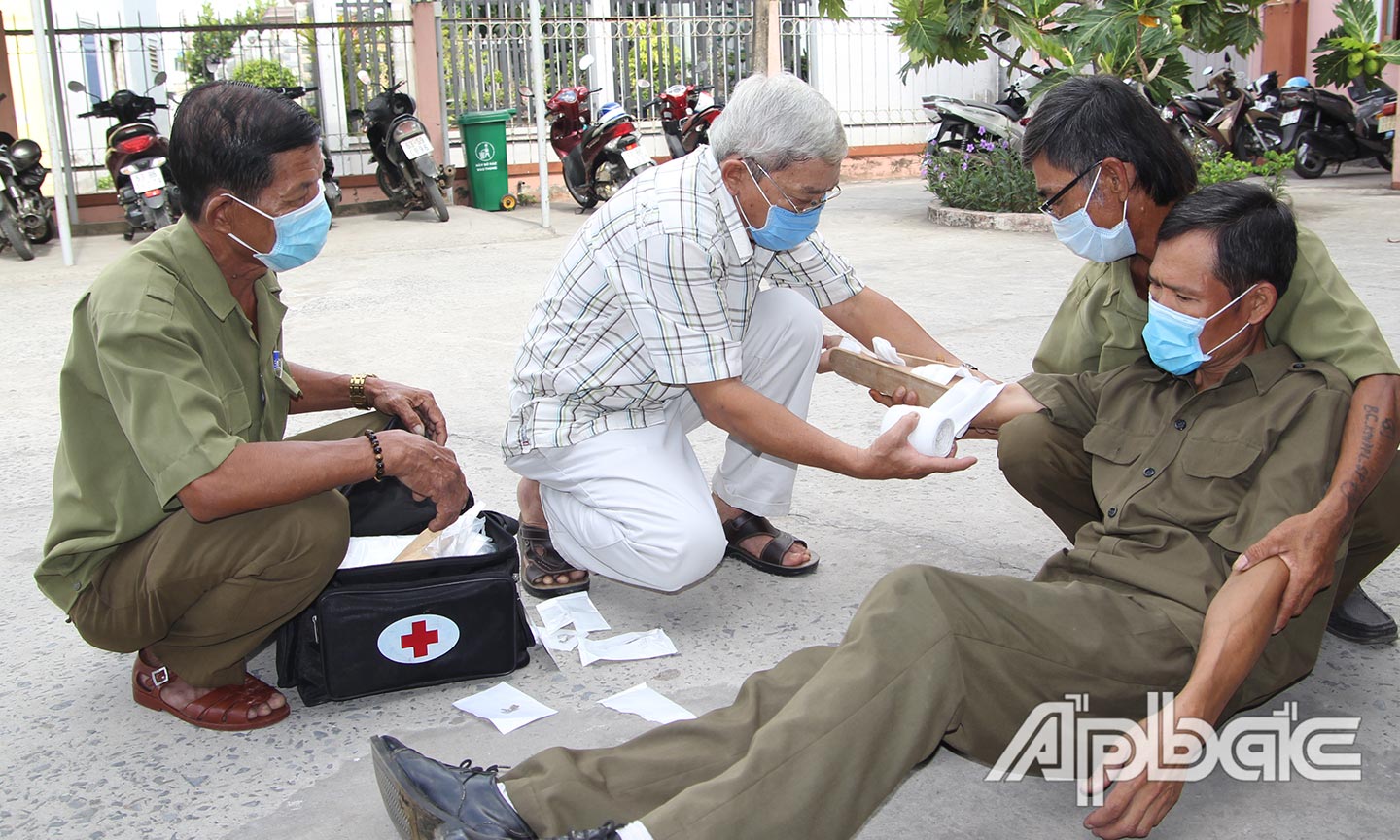Các thành viên “Tổ cấp cứu ATGT phường 4” diễn tập sơ cứu người tai nạn giao thông.