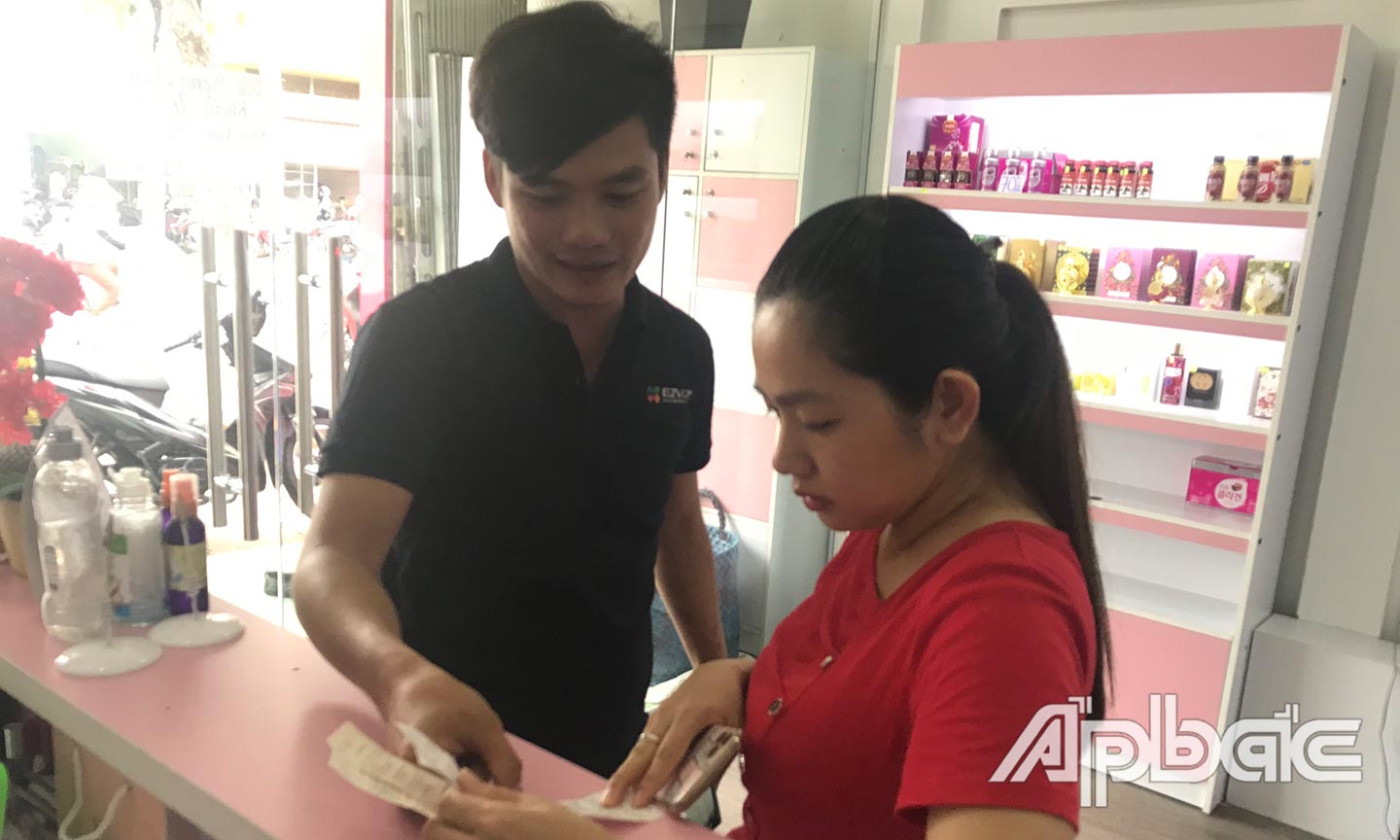 Chị Hồng Cẩm kiểm tra hóa đơn tiền điện trước và sau khi lắp đặt hệ thống.