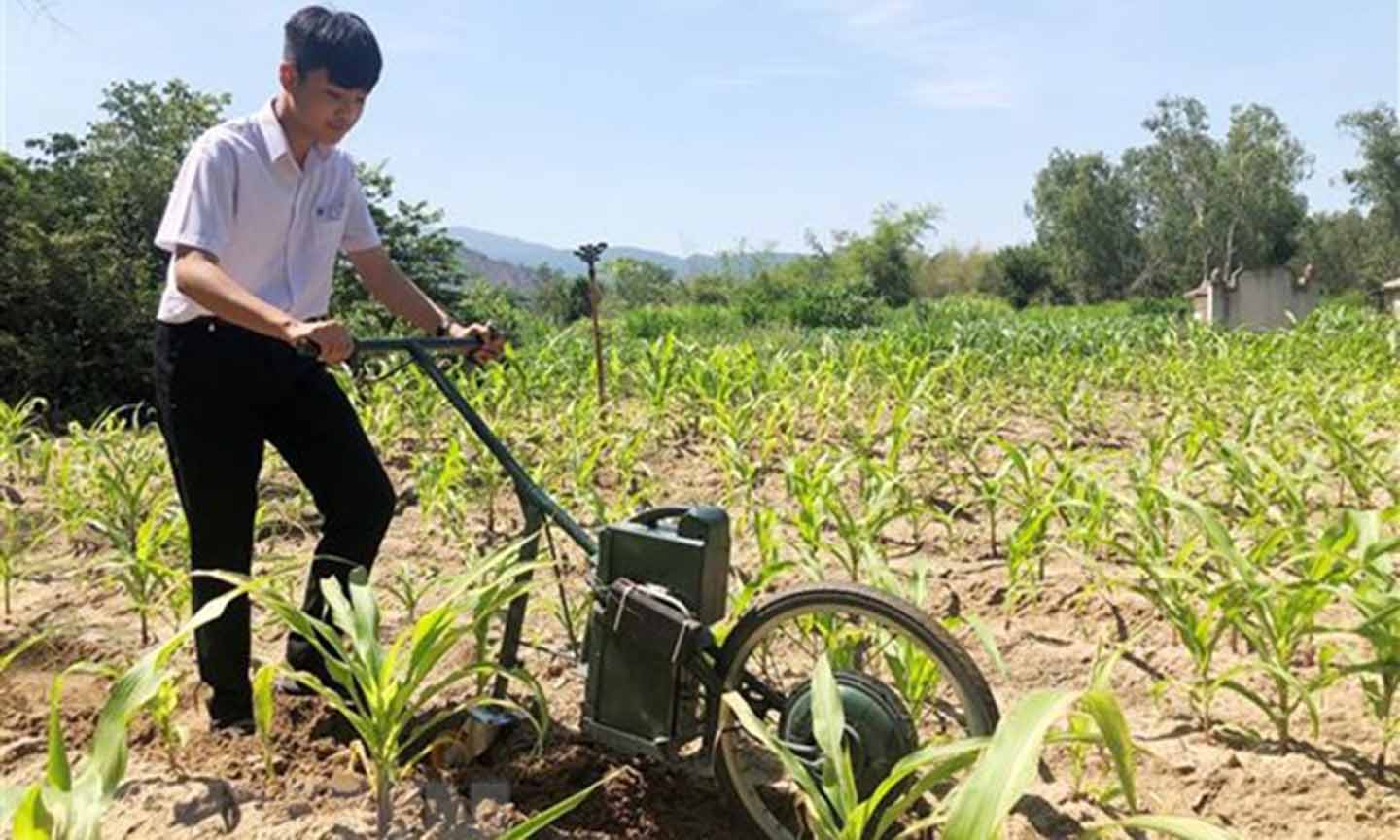 Em Lê Tuấn Kiệt với máy cày làm cỏ, bón phân. (Ảnh: Nguyên Linh/TTXVN)