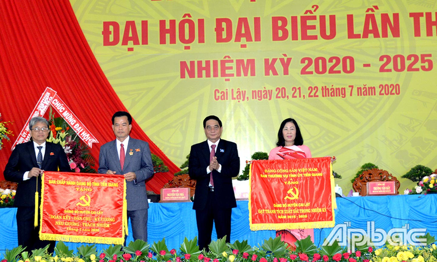 Đồng chí Nguyễn Văn Nhã, Ủy viên Ban Thường vụ, Trưởng Ban Tổ chức Tỉnh ủy trao Bức trướng của Ban Chấp hành Đảng bộ tỉnh và trao Cờ thi đua của Ban Thường vụ Tỉnh ủy tặng Đảng bộ huyện Cai Lậy tại Đại hội. Ảnh: HẠNH NGA