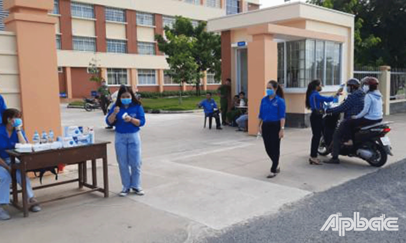 Hỗ trợ thí sinh đo thân nhiệt trước khi vào phòng thi