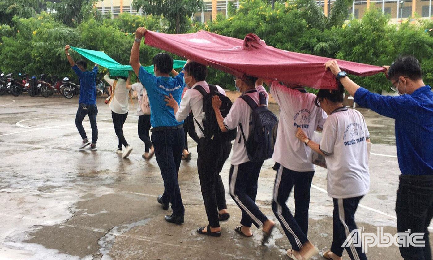 Hỗ trợ thí sinh vào phòng thi khỏi bị ướt khi trời mưa