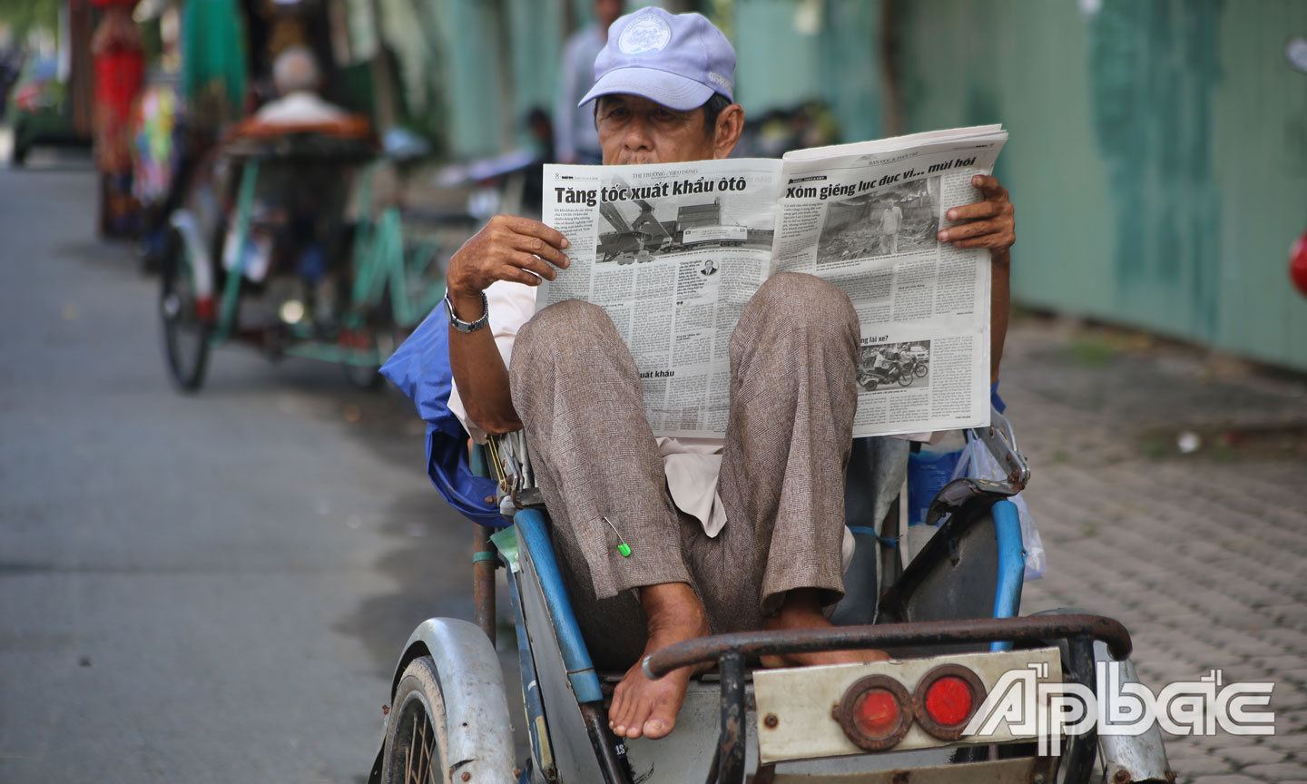Giây phút bình yên của chú xích lô ngồi đọc báo. 