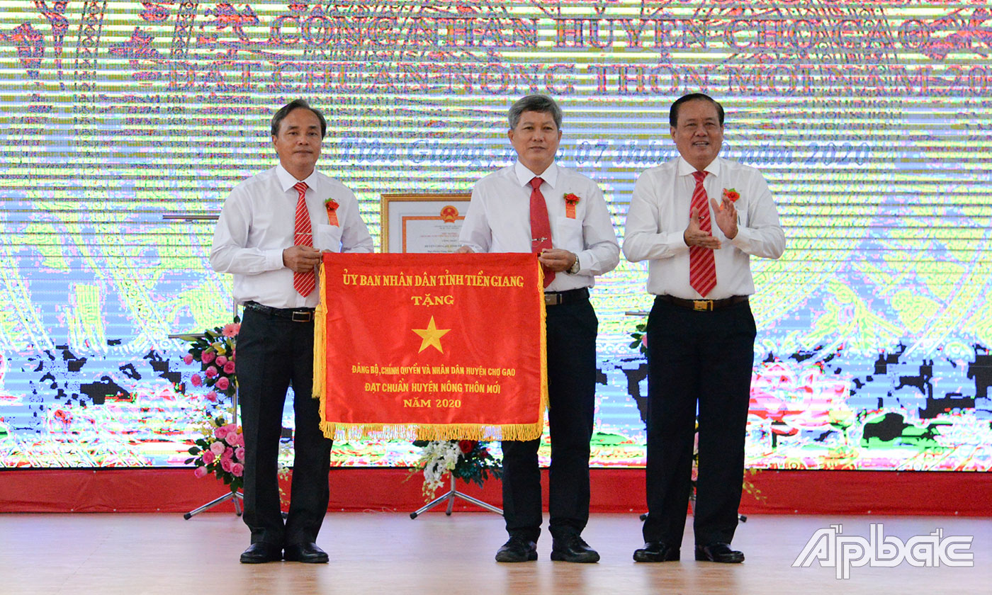 Phó Chủ tịch Thường trực UBND tỉnh Lê Văn Nghĩa trao Cờ thi đua cho Đảng bộ, chính quyền và nhân dân huyện Chợ Gạo đạt chuẩn NTM năm 2020.