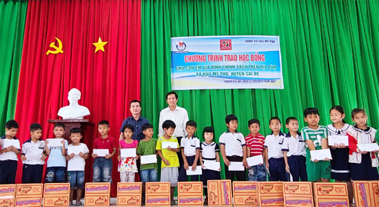 Ông Trương Vân Đoàn - Phó Giám đốc Agribank Tiền Giang (áo trắng) và Ông Dương Vũ Thông - Phó Chủ tịch Hội Nhà báo trao học bổng cho các cháu.