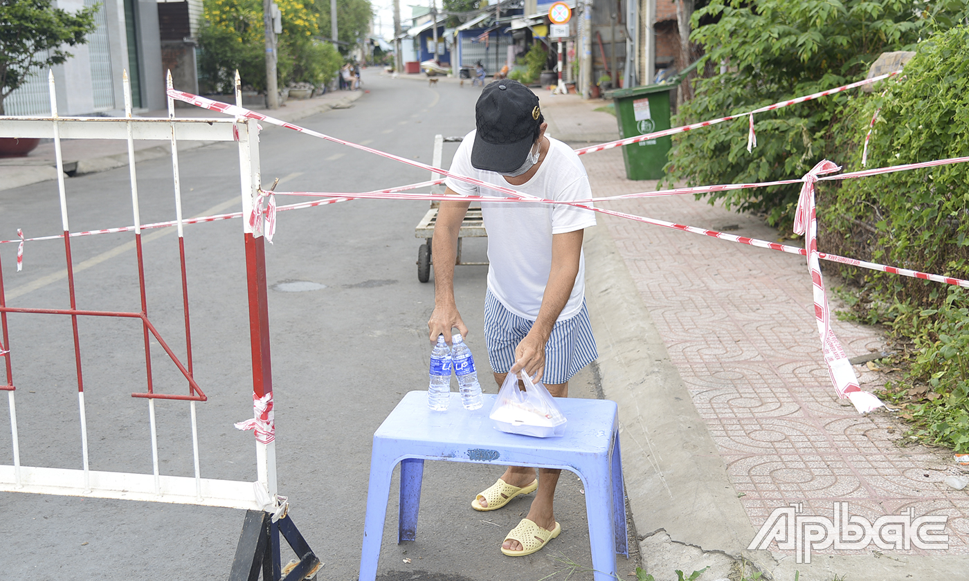 Người dân khu vực phong tỏa cảng cá Phường 2 nhận thực phẩm người thân gửi vào.