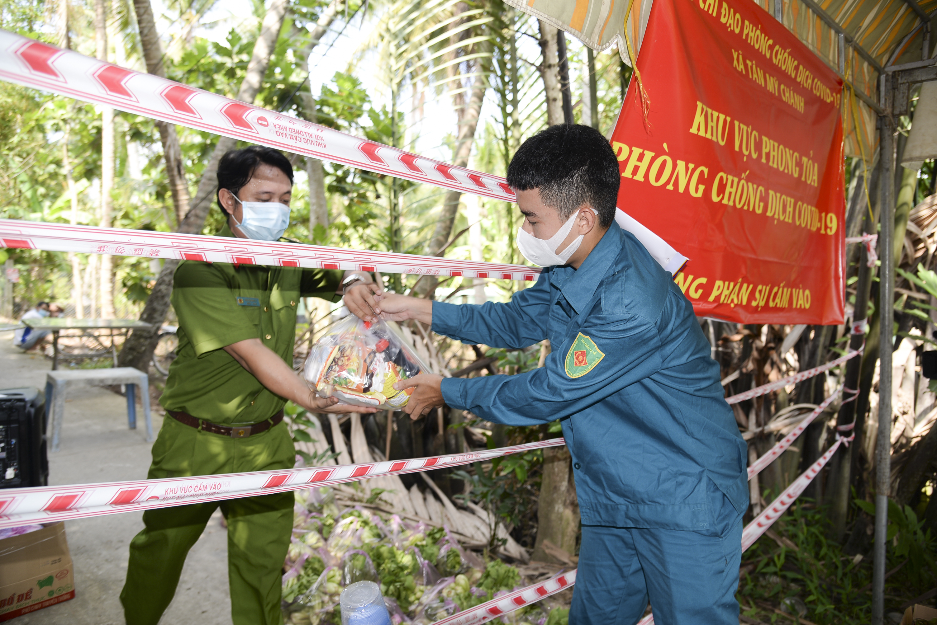 Các lực lượng xã Tân Mỹ Chánh vận chuyển thực phẩm, nhu yếu phẩm cho người dân Tổ 6, ấp Phong Thuận. khu vực phong tỏa