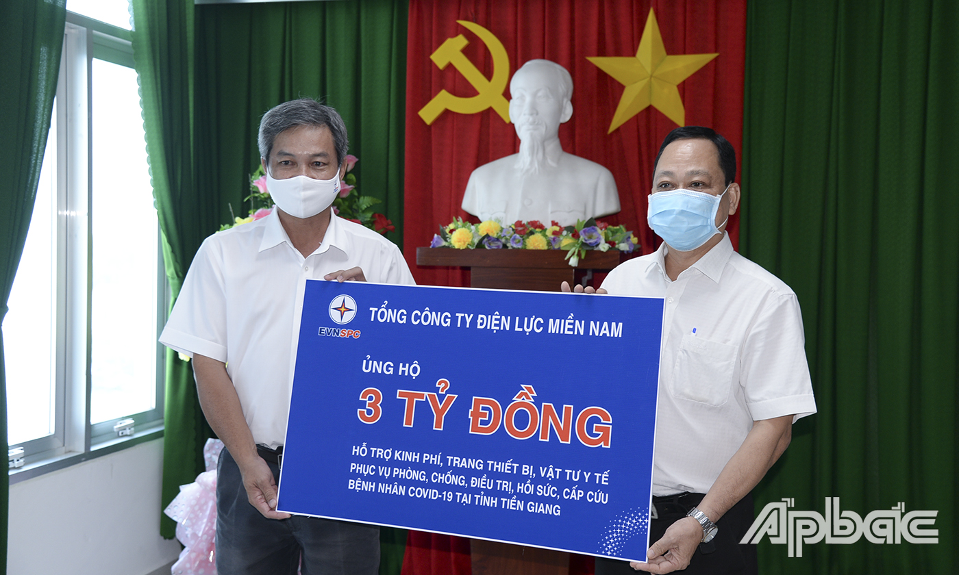 Ông Lê Hữu Đức, Giám đốc Công ty Điện lực Tiền Giang trao bảng tượng trưng hỗ trợ kinh phí của Tổng Công ty Điện lực miền Nam cho Sở Y tế.