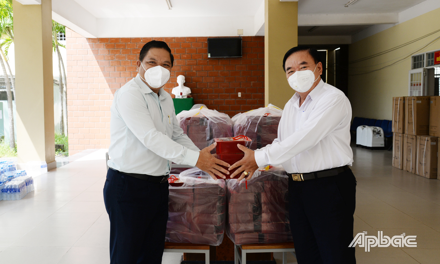 Đồng chí Lý Văn Cẩm (bên trái) trao quà trung thu đến Phó Giám đốc Bệnh viện dã chiến số 7 để trao tặng cho 120 trẻ em là F0 đang điều trị tại đây