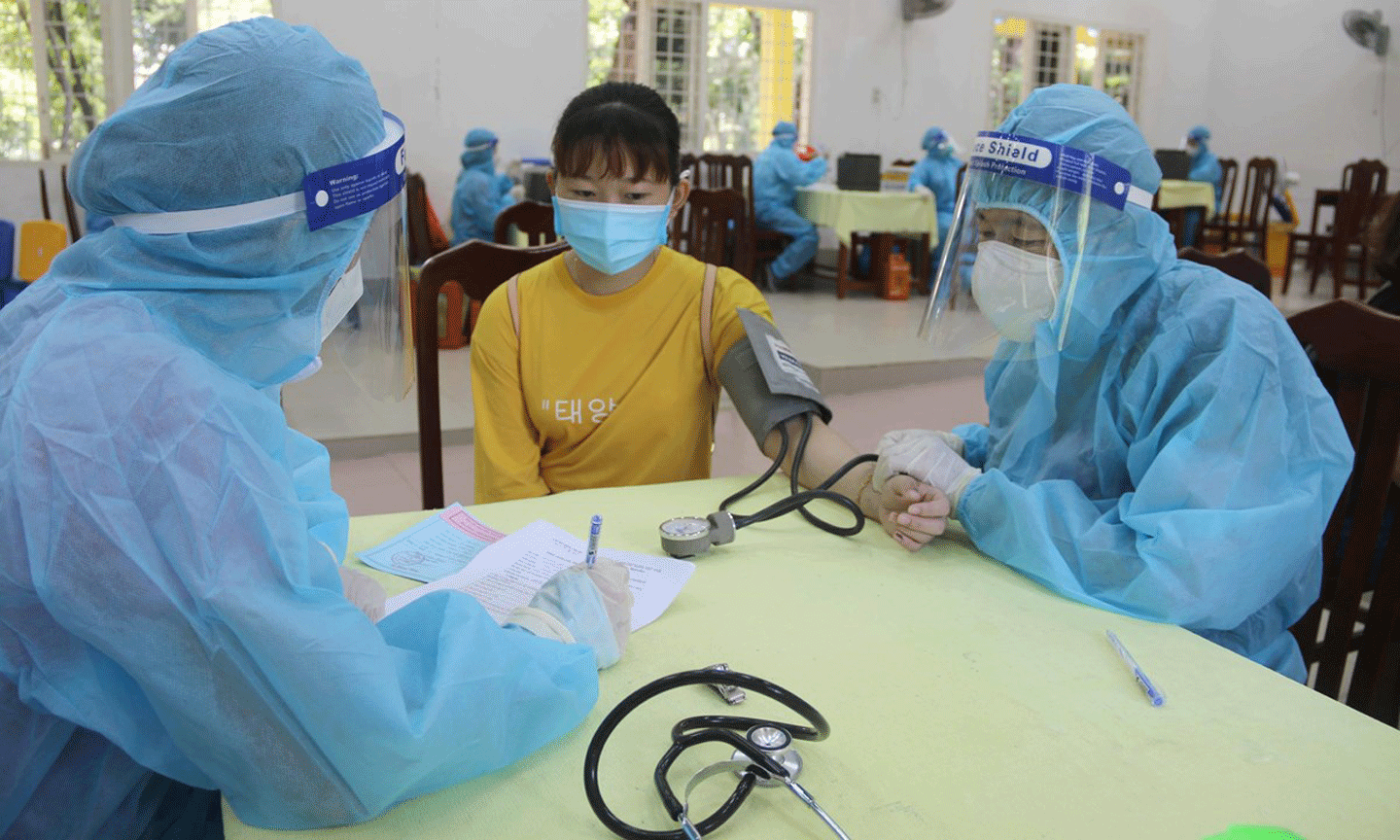 Khám sàng lọc trước khi tiêm vaccine tại điểm tiêm trường Đại học Trà Vinh. (Ảnh: Thanh Hòa/TTXVN)