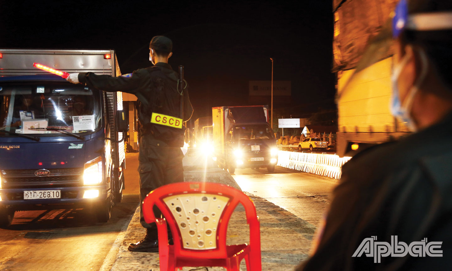 Nhập nhòa ánh đèn đêm, 2 chiến sĩ Cảnh sát cơ động phải kiểm tra từng tài xế, ghi nhận từng xe.