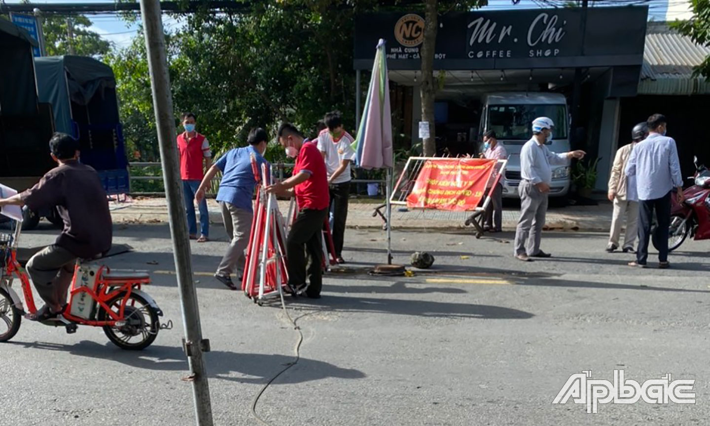 Các lực lượng tiến hành tháo dỡ chốt trên đường Đinh Bộ Lĩnh, TP. Mỹ Tho, Tiền Giang. Ảnh: Hoàng Long