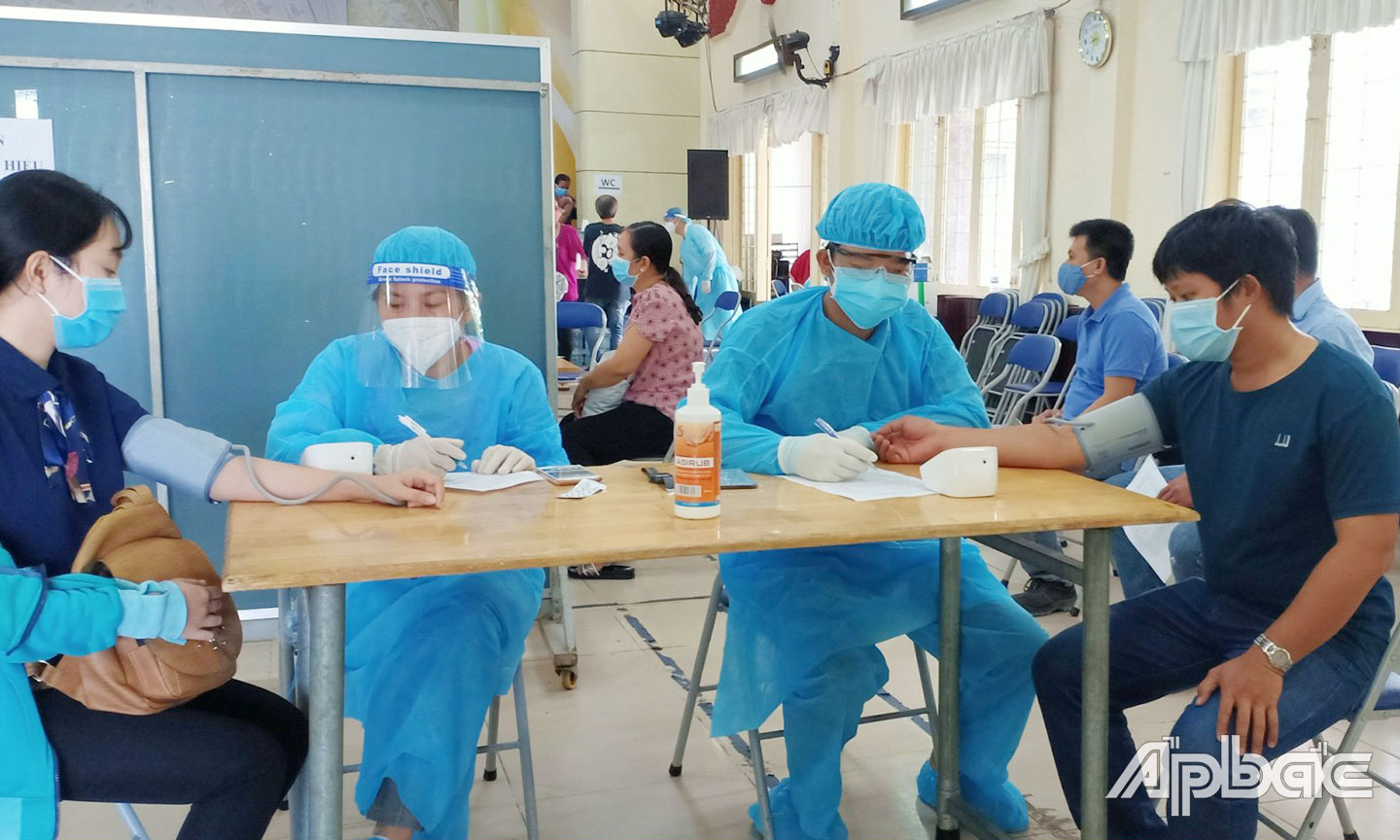 Tình nguyện viên Trường Đại học Tiền Giang hỗ trợ công tác tiêm vắc xin Covid-19 tại Trung tâm Văn hóa - Nghệ thuật Tiền Giang. Ảnh: Lê Tân