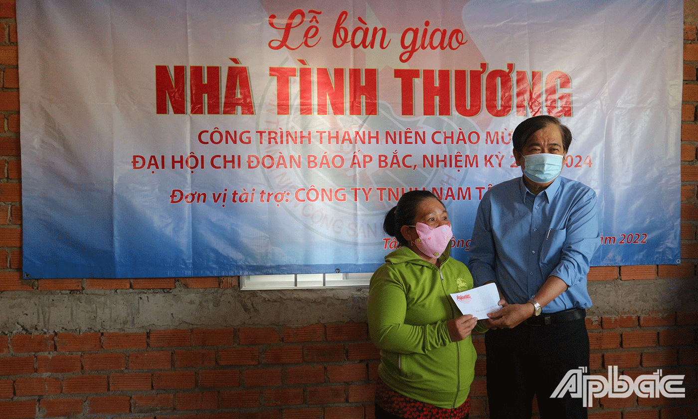 Tổng Biên tập Báo Ấp Bắc Nguyễn Minh Tân trao quà chúc mừng chị Loan xây cất được ngôi nhà mới, khang trang