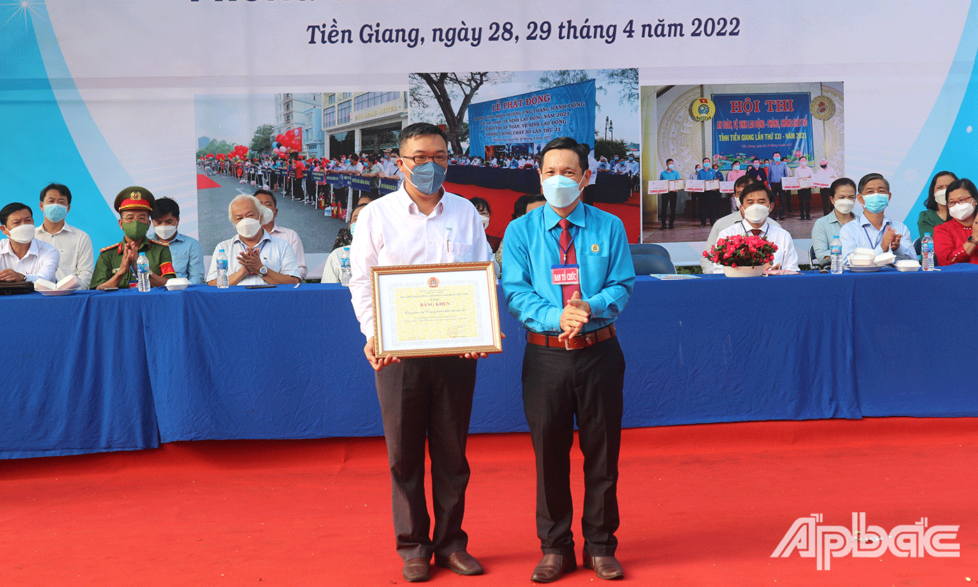 Đồng chí Lê Minh Hùng Chủ tịch Liên đoàn Lao động tỉnh Tiền Giang trao tặng Bằng khen của Tổng Liên đoàn Lao động Việt Nam cho 1 tập thể có thành tích xuất sắc trong phong trào “Xanh - Sạch - Đẹp, bảo đảm an toàn vệ sinh lao động” năm 2021