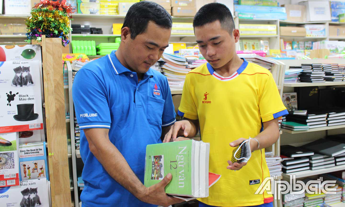 Phụ huynh vả học sinh chọn mua SGK. Ảnh: P.CÔNG